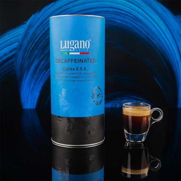 Lugano Caffè Decaffeinated Espresso Pod 18 pcs cylinder pack and a cup in a studio set