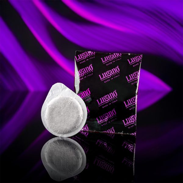 Lugano Caffè Elite Dark Espresso Pod with its aluminum foil in a studio set