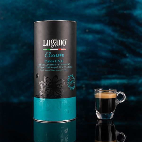 Lugano Caffè Elite Life Espresso Pod 18 pcs cylinder pack with a cup in a studio set